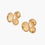 Three hammered gold discs clustered together forming organic statement earrings with textured surfaces